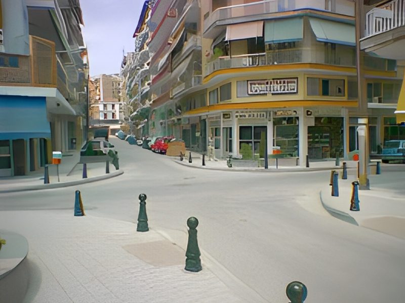 A street with many cars parked on the side of it.