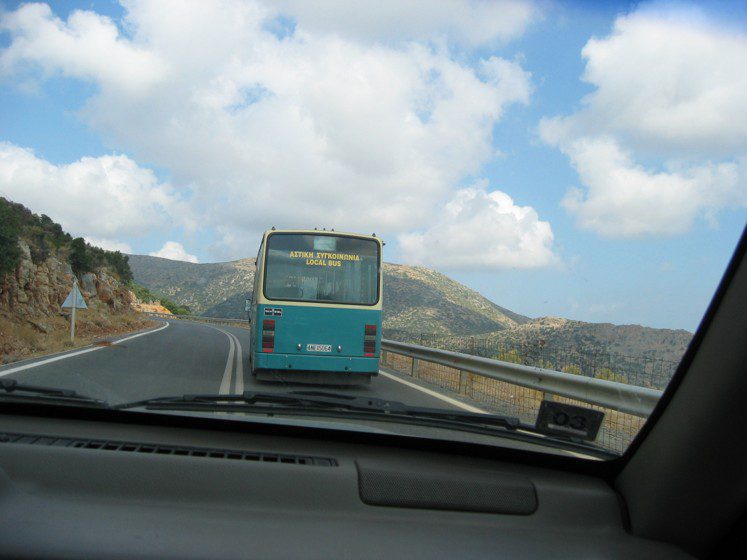 A bus driving down the road on a cloudy day.